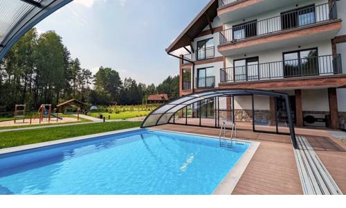Oblast Mazurských jezer blízko výletních cílů: Apartament Karwica Zapach Lasu s bazénem, saunou a hřištěm